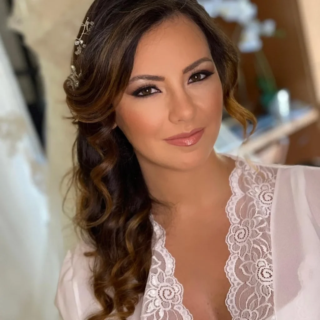Ritratto di sposa con capelli castani mossi, accessorio gioiello e trucco soft glam