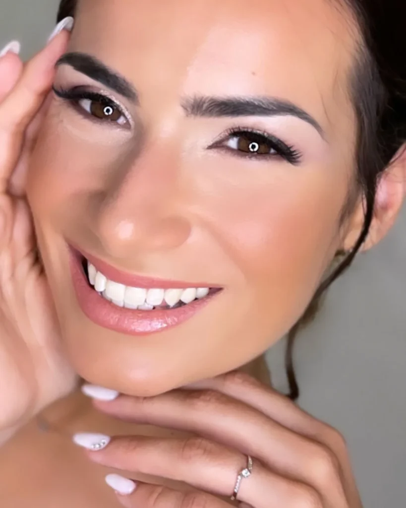 Sposa sorridente in primo piano con eyeliner e labbra rosa naturale